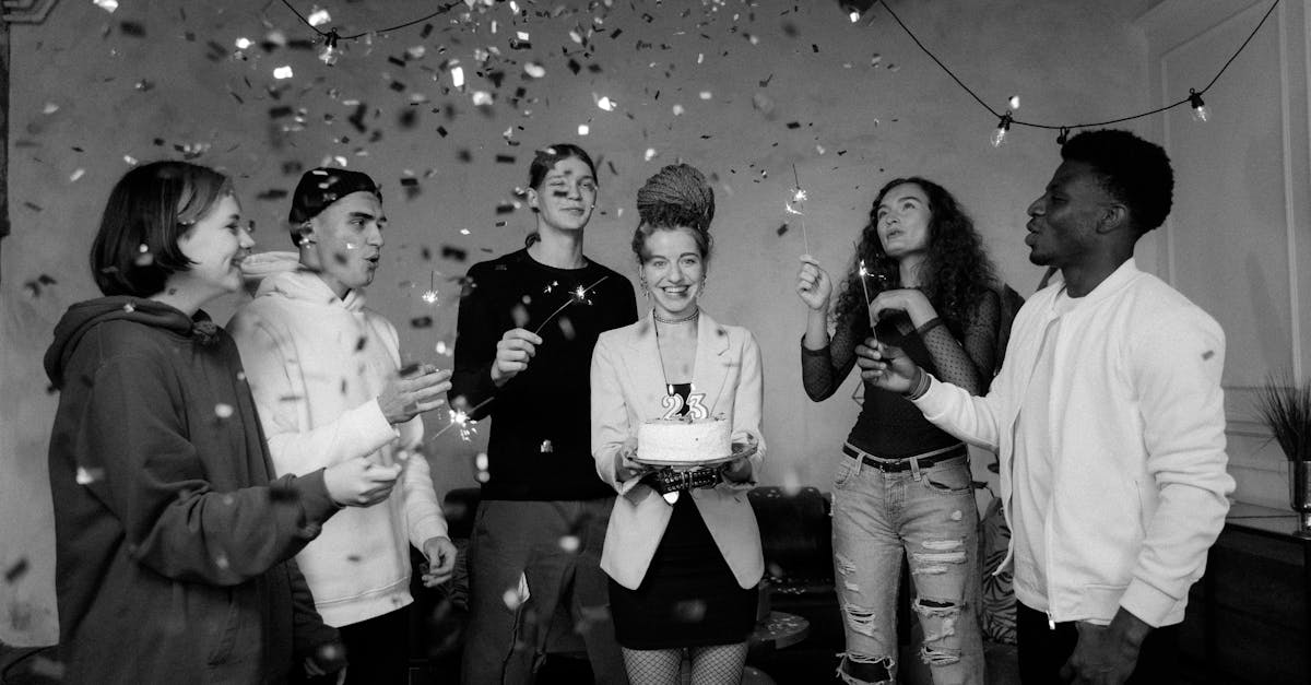 A joyful group celebrates a birthday with confetti and cupcakes indoors, capturing diversity and happiness.