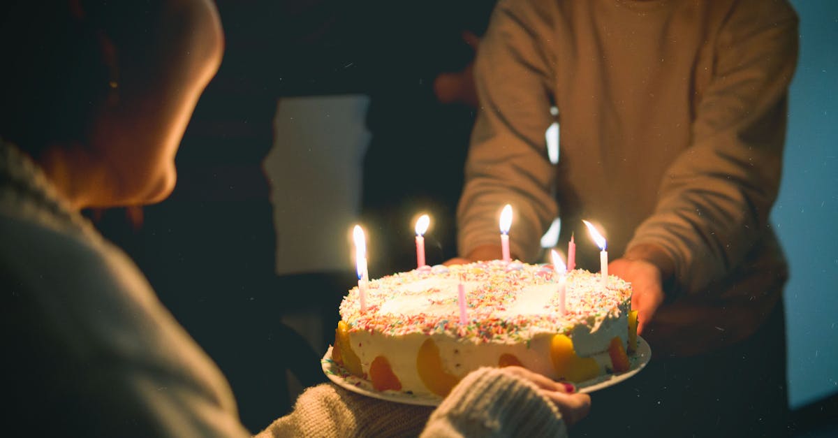 Warm and festive birthday scene featuring a colorful cake with lit candles, captured indoors.