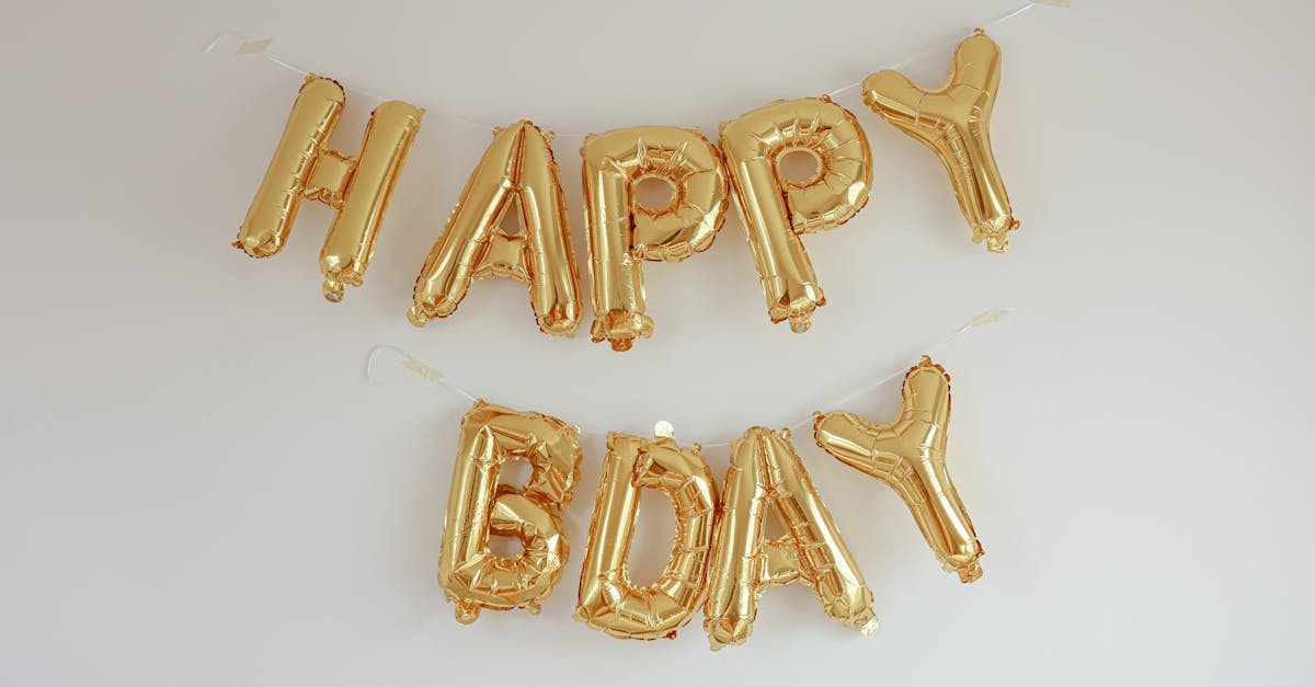 Elegant gold balloon letters spelling 'Happy Bday' on a white background for a birthday celebration.