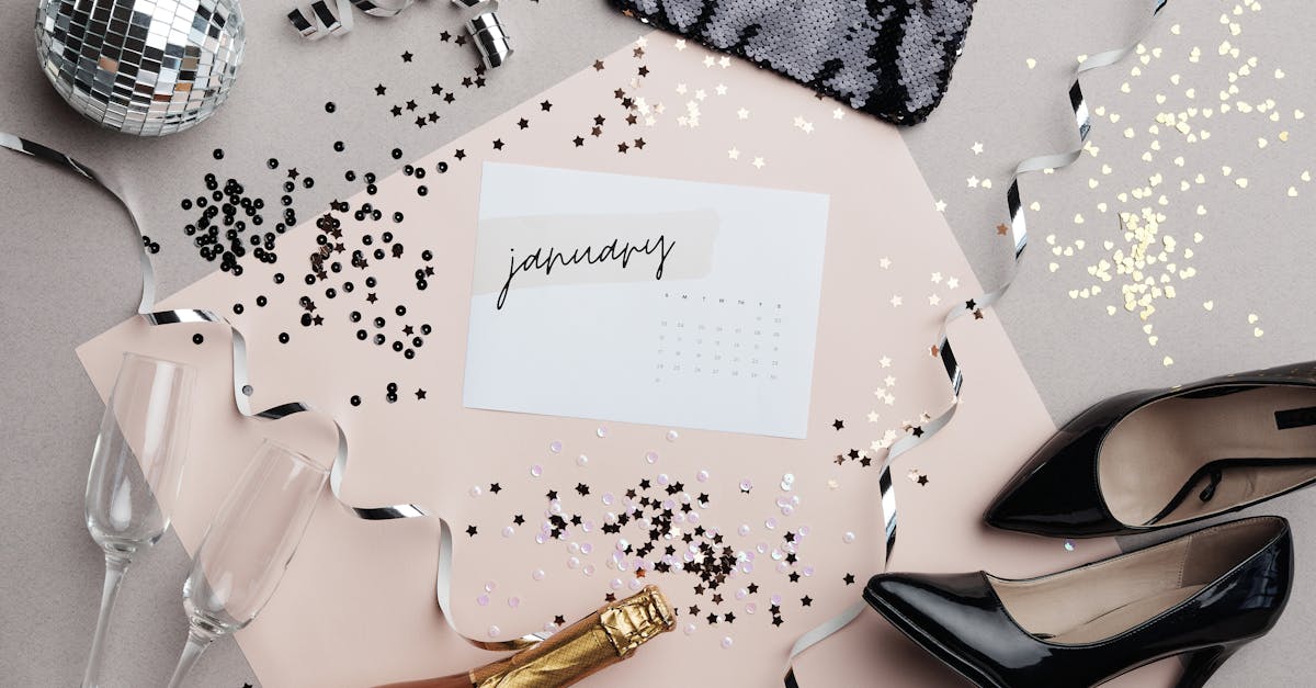 Stylish New Year flat lay featuring January calendar, champagne, high heels, and festive decor.