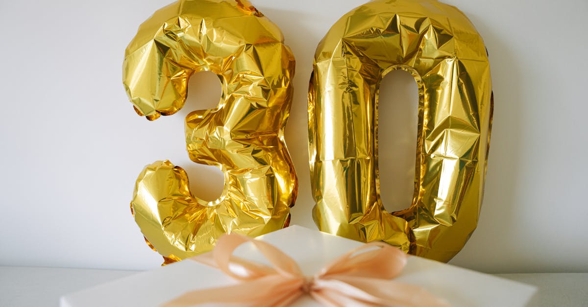 Golden 30 balloon with a wrapped gift box for a 30th celebration or birthday.