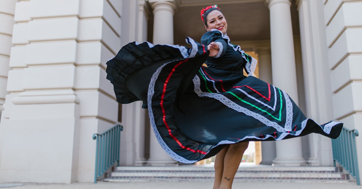 Woman performing traditional Mexican dance in colorful dress outside historic building.