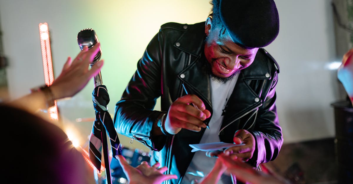 A joyful musician in a leather jacket signing autographs during a lively event.