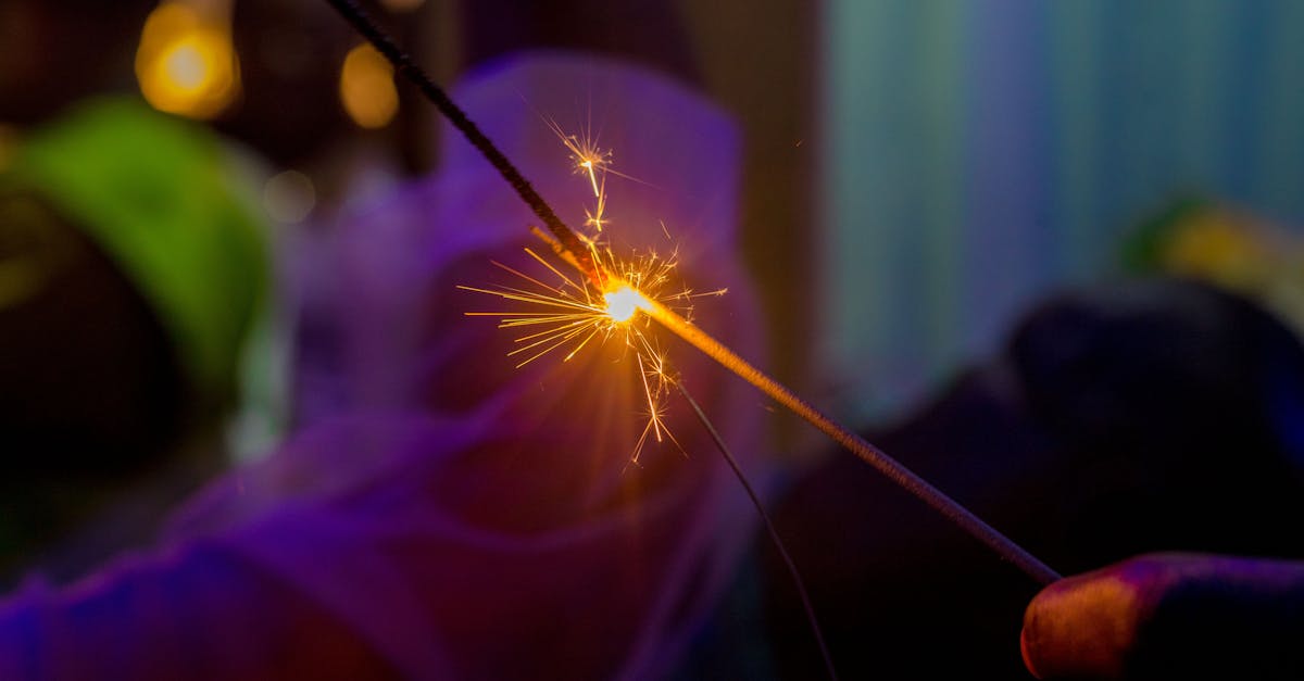 Close-up of a sparkler creating bright sparks at a festive event.