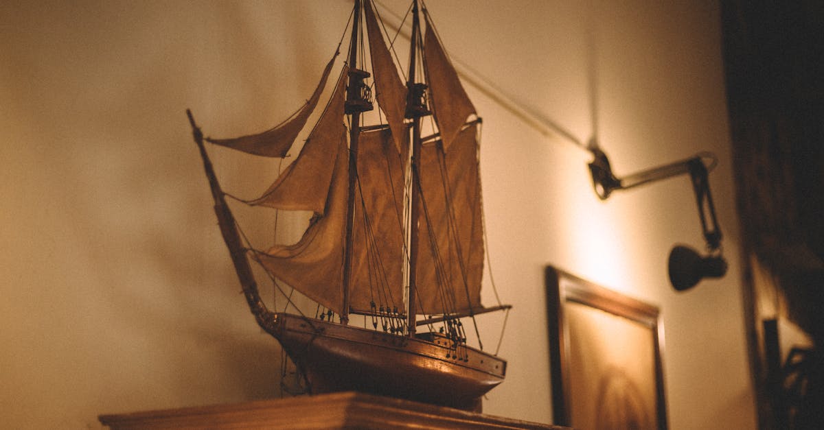 A beautifully crafted vintage sailboat model displayed in a warm, cozy indoor space with a nostalgic ambiance.